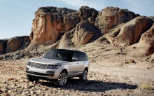 Серебристый Range Rover,  скалы позади Рендж Ровера, бездорожье